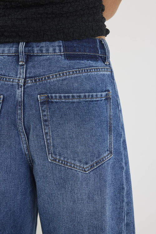 Close-up of blue jeans with a plain background