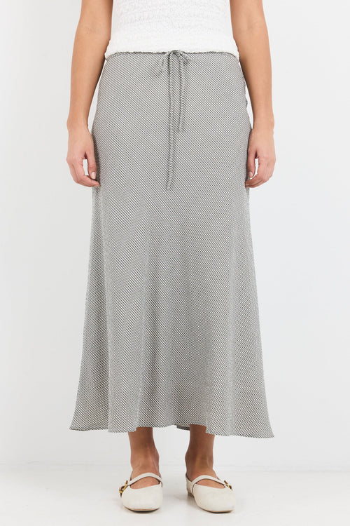 Person wearing a gray patterned skirt on a white background