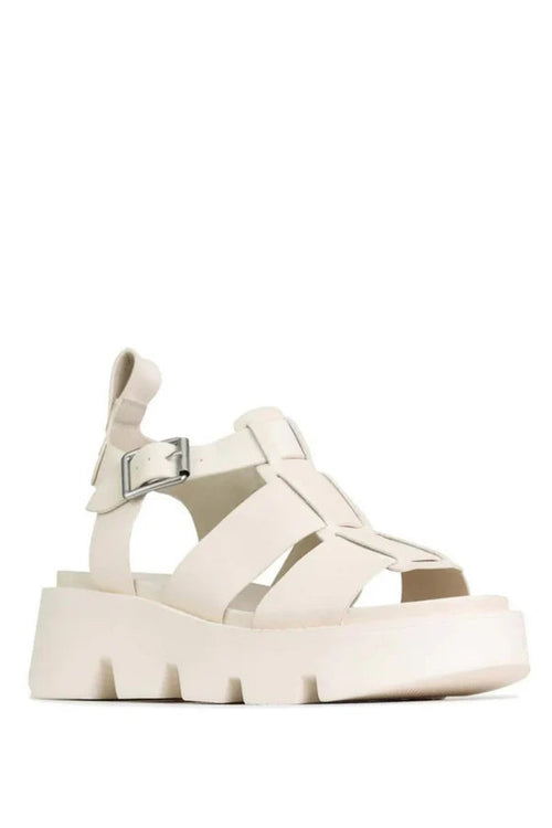 A single platform sandal in off-white leather with cutout straps, an ankle strap with a silver buckle, and a chunky lug sole, shown against a plain white background.