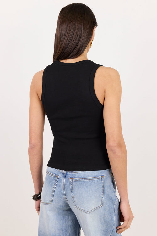 A woman viewed from behind wearing a fitted black sleeveless top and light blue jeans against a plain white studio background.