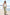A woman walking on a sunny seaside boardwalk wearing a white sleeveless top and a green and white gingham maxi skirt, with sunglasses and white sandals.