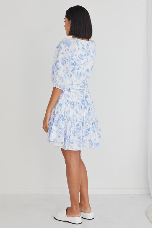 model wears a blue floral mini dress