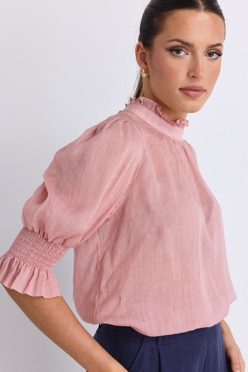 model wears a pink blouse