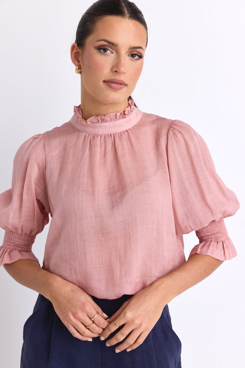 model wears a pink blouse