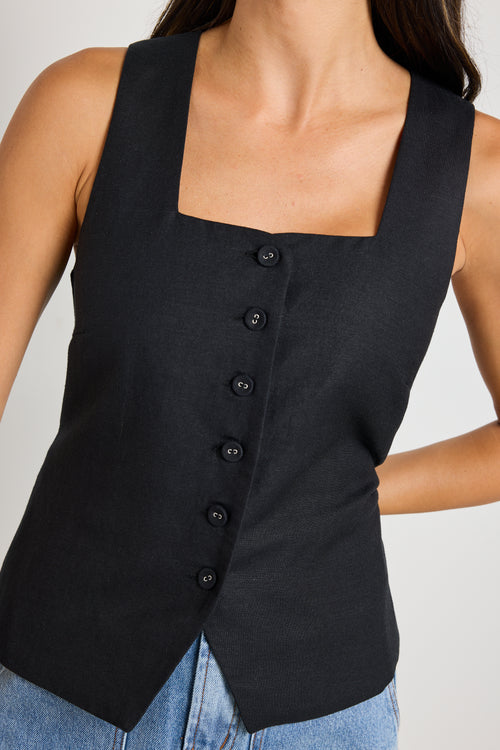 model wears a black linen vest