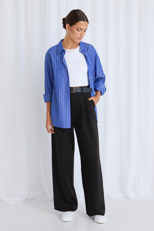 model wears black pants with a blue shirt