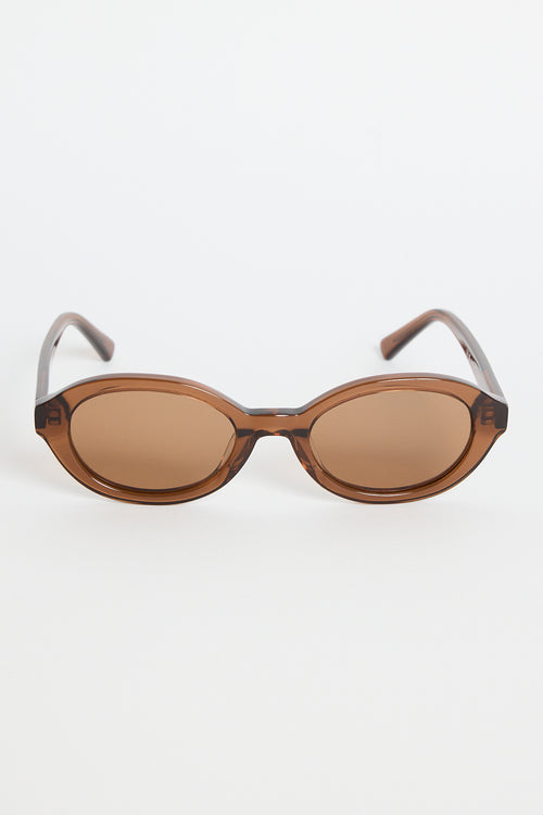 Espresso-brown oval sunglasses with tinted lenses and slim arms featuring RE:UNION label branding, photographed on a white background
