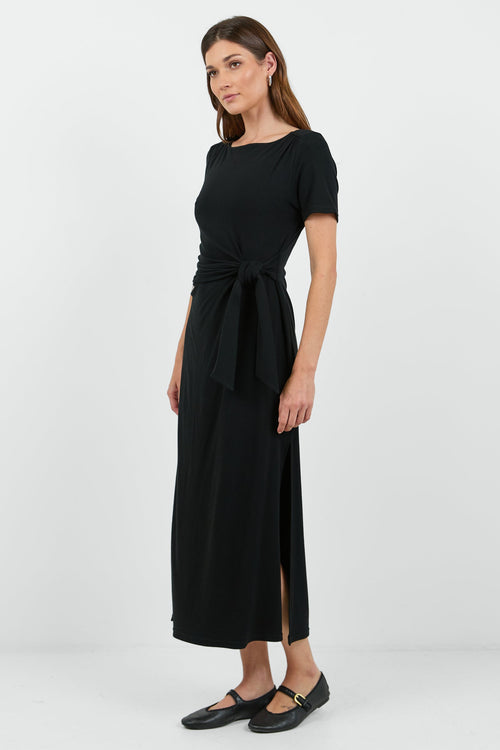 This black dress features a flattering side tie detail and a relaxed fit, perfect for both casual and dressy occasions.