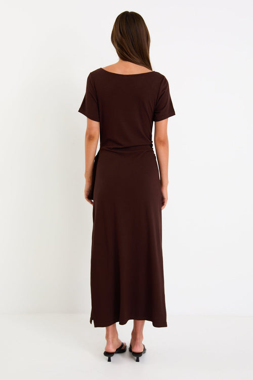 Model wearing a chocolate brown short sleeve jersey maxi dress with a waist tie and side split