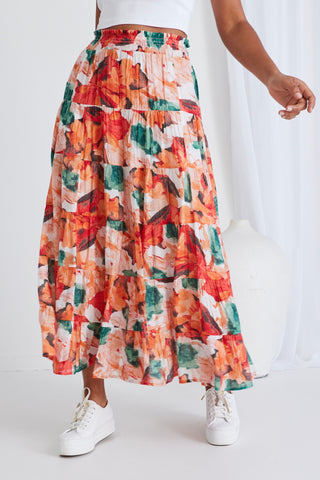 model wears a orange print maxi skirt
