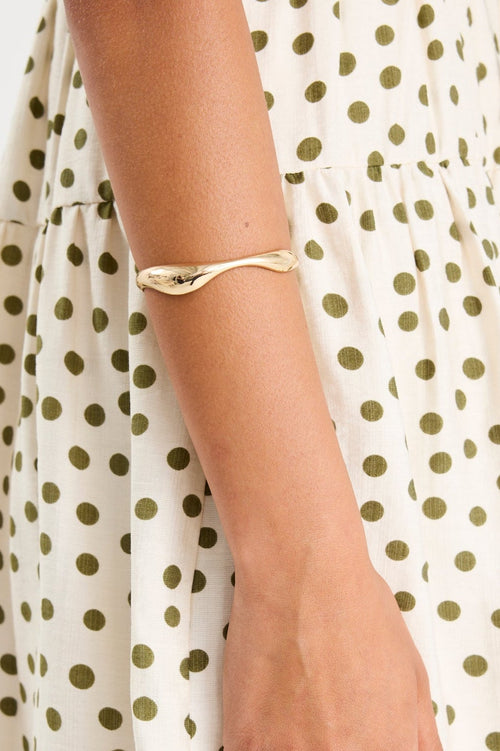 Woman wearing a gold cuff bangle