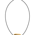 A minimalist adjustable cord necklace featuring a smooth, organic-shaped gold pendant with a dark brown center, displayed on a clean white background.