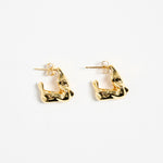 gold-plated brass huggie earrings with a wavy, organic design, photographed flat against a white background.
