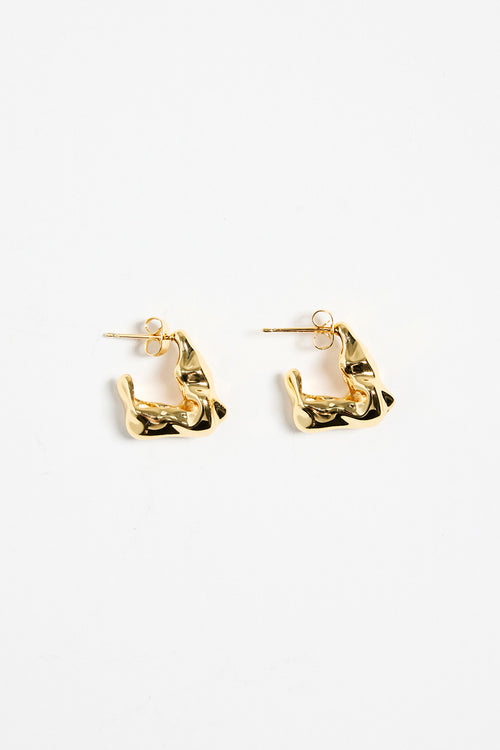 gold-plated brass huggie earrings with a wavy, organic design, photographed flat against a white background.
