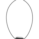 A minimalist black cord necklace featuring a smooth, irregular-shaped dark gray stone pendant set in a polished silver bezel, shown against a solid white background.
