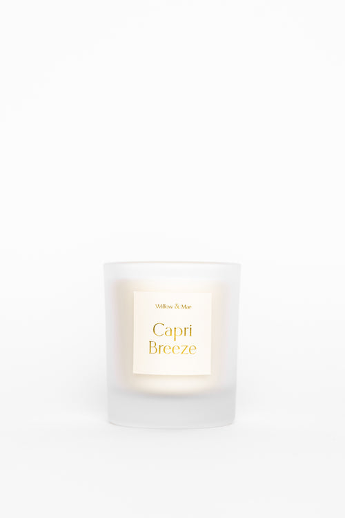 White candle labeled 'Capri Breeze' on a white background