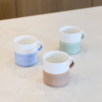  Artist Ice Blue hand painted two tone stackable mug shown alongside green and taupe colourways for styling reference; listing is for the blue mug only.
