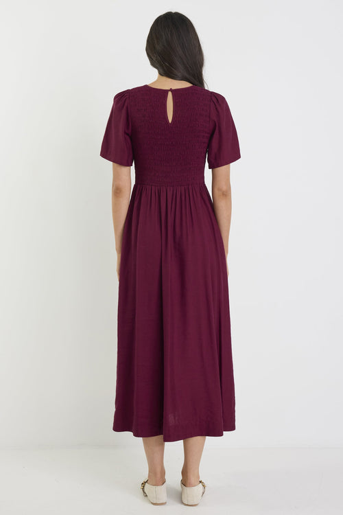 Woman wearing a burgundy dress on a white background