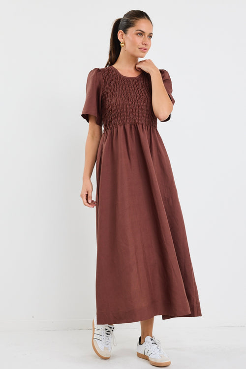 Model wears brown midi dress with a shirred cotton bodice and short sleeves