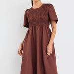 Model wears brown midi dress with a shirred cotton bodice and short sleeves
