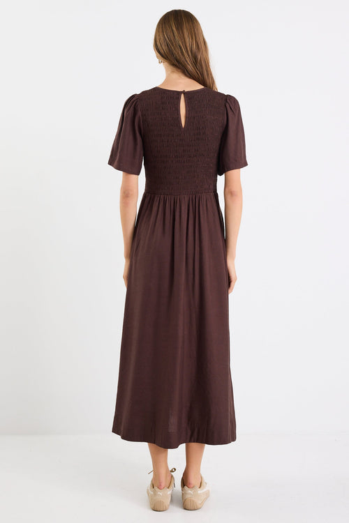 Woman wearing a brown dress on a white background