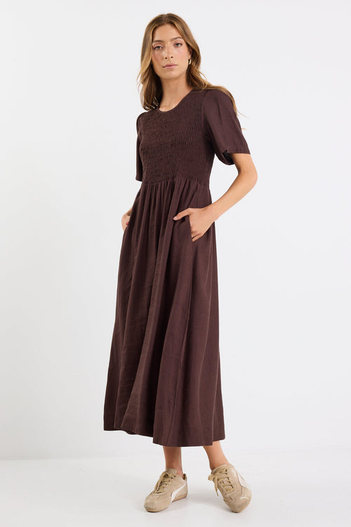 Woman wearing a brown dress on a white background