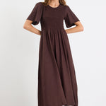 Woman wearing a brown dress on a white background