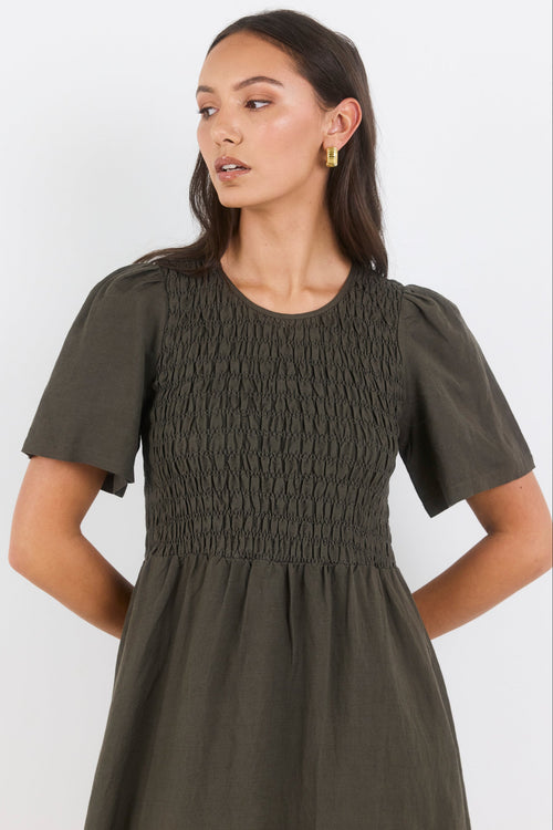 Woman wearing a green dress against a white background