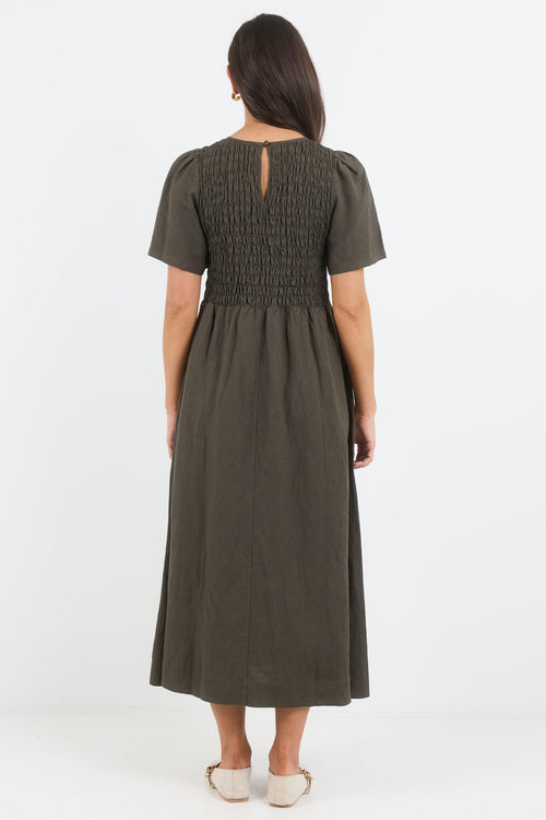 Woman wearing a green dress from behind on a white background