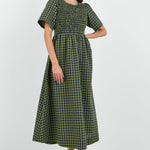 Woman wearing a green checkered dress on a white background