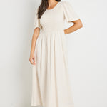 model wears a shirred natural maxi dress