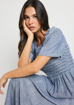 Woman wearing a blue dress against a white background