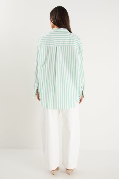 Person wearing a light green and white striped shirt and white pants on a plain background
col_pattern