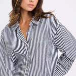 Woman wearing a black and white striped shirt against a white background