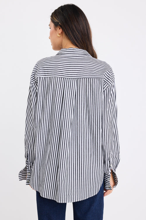 model wears a black and white stripe shirt with dark denim jeans
col_pattern