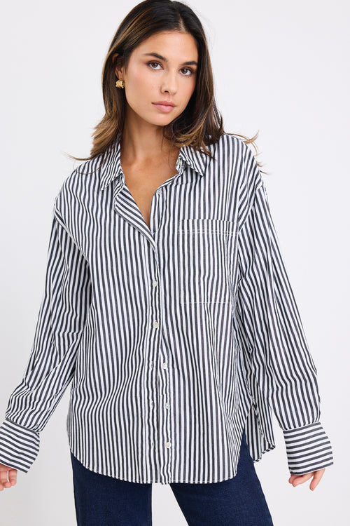 model wears a black and white stripe shirt with dark denim jeans