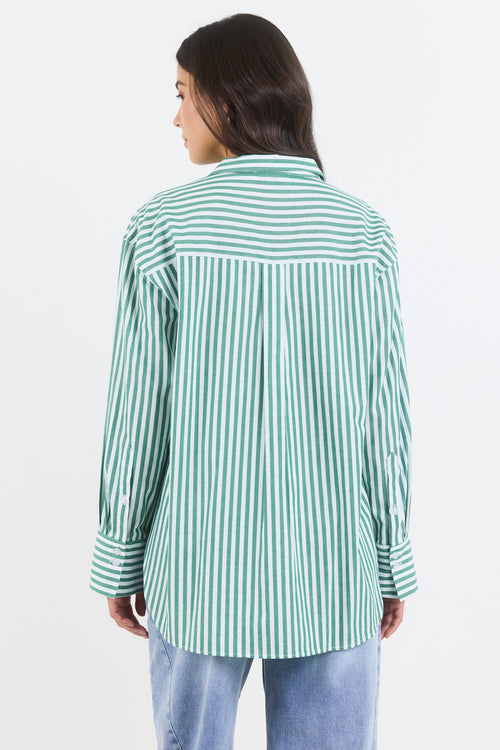 Person wearing a green and white striped shirt on a white background