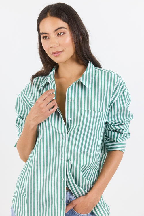 Woman wearing a green and white striped shirt on a white background