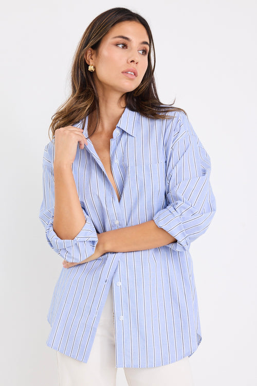 model wears a blue stripe shirt with ecru jeans