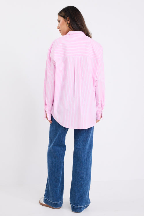 model wears a pink and white stripe shirt with dark blue jeans
col_pattern