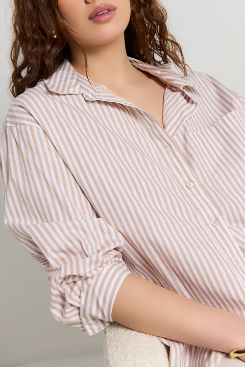 Model wears a stripe white and tan shirt 