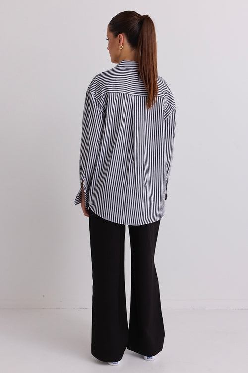 model wears a black and white stripe shirt 