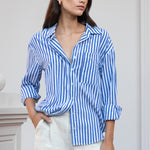 Model wearing a blue white striped shirt and beige pants