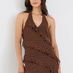 Woman wearing a brown polka dot dress on a white background