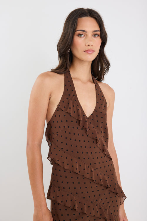 Woman wearing a brown polka dot dress against a white background