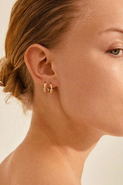 model wears Gold Twist Hoop Earrings