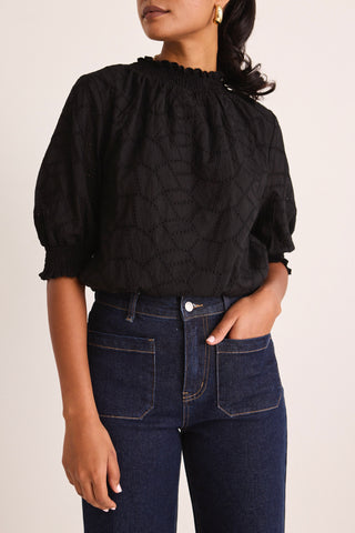 model wears a black blouse 