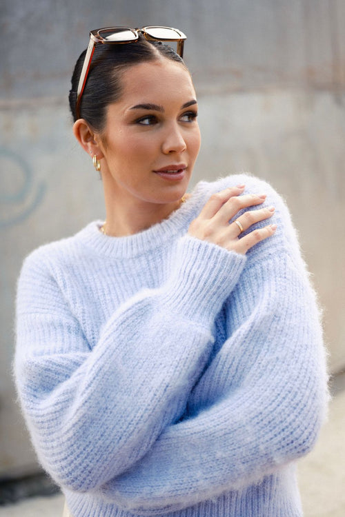 model wears a purple knit jumper