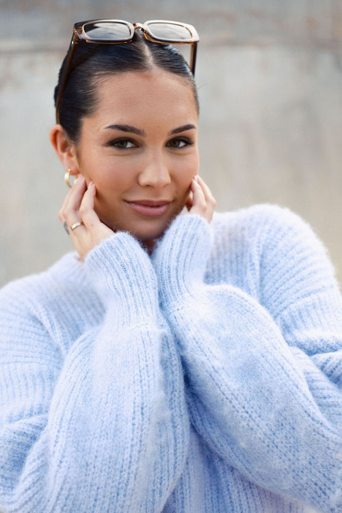 model wears a purple knit jumper