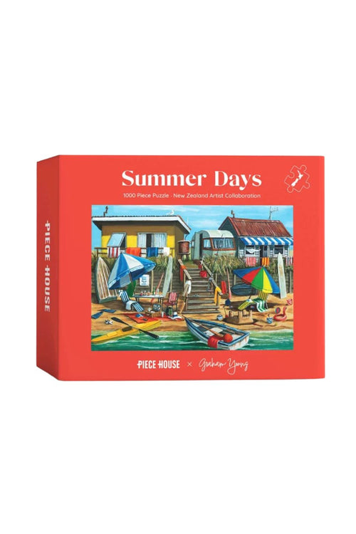 A red jigsaw puzzle box titled 'Summer Days' by artist Graham Young, featuring a colorful illustration of a beachside village scene on the front.